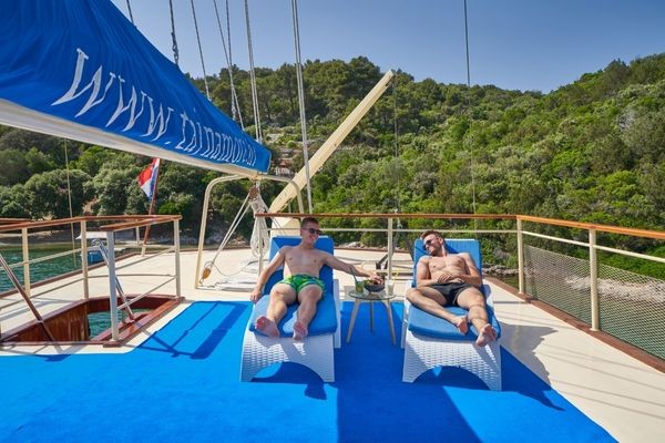 Two friends laying on sundecks and having fun
