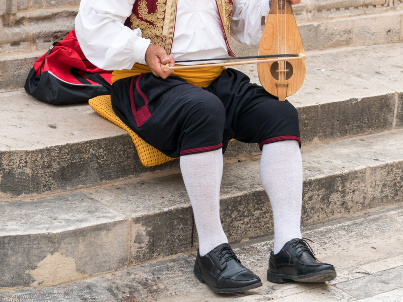 Musician playing the traditional instrument lijerica on the Streets of Dubrovnik